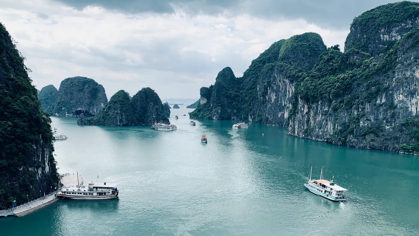 Sightseeing boats on turquoise water in Ha Long Bay, Vietnam